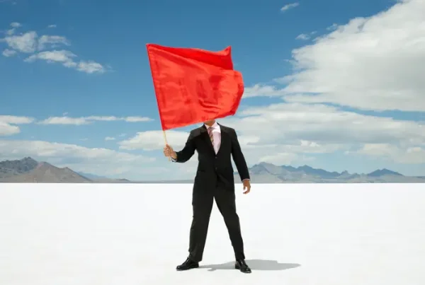 man standing with a red flag waving